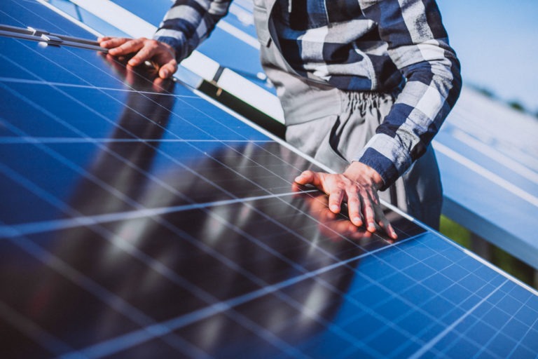 man worker in the firld by the solar panels panneau solaire qualipv