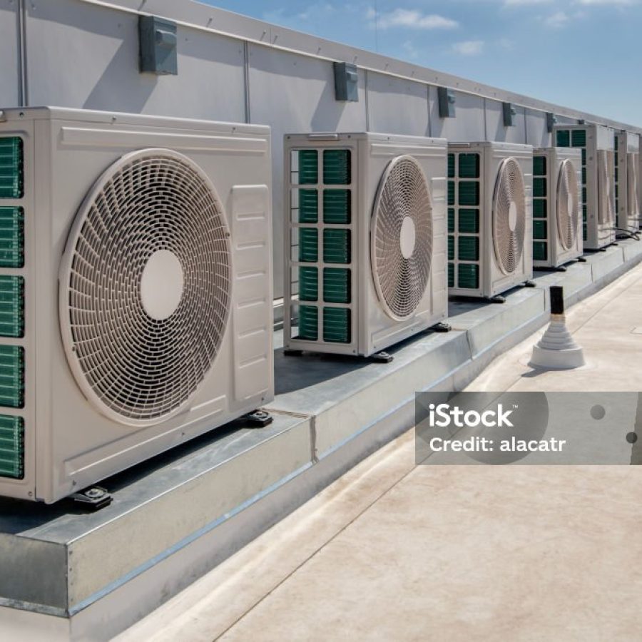 long row of air conditioner units on a membrane roof.