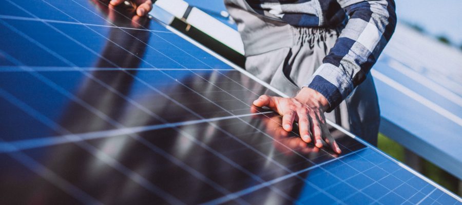 man worker in the firld by the solar panels panneau solaire qualipv