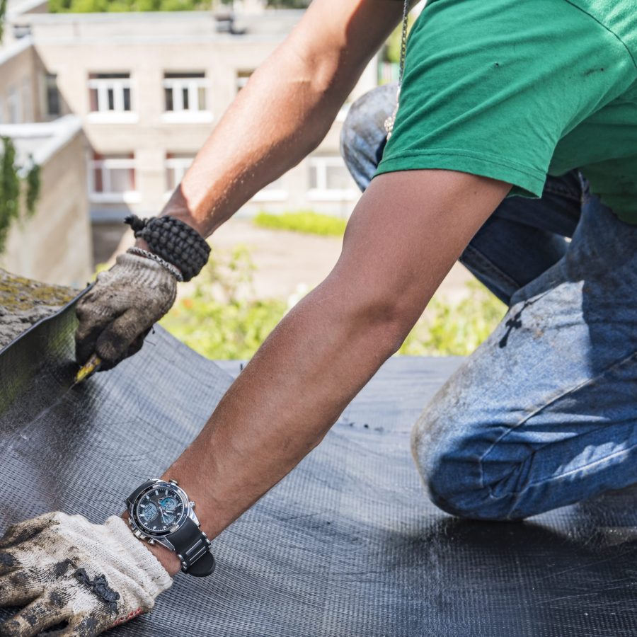 worker performs overhaul of the roof of a residential building Etanchéité toit terrasse -EPDM